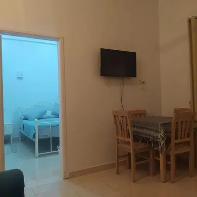 a room with a table and a television and a bed at Luxor Palm Villa in Luxor