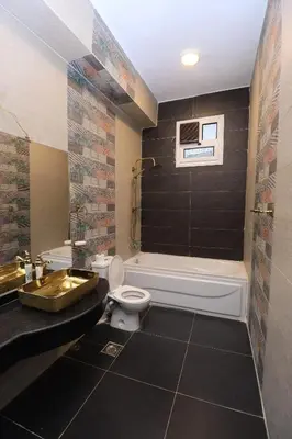 a bathroom with a tub and a toilet and a sink at Pearl of Luxor on the Nile -Apartment in Luxor