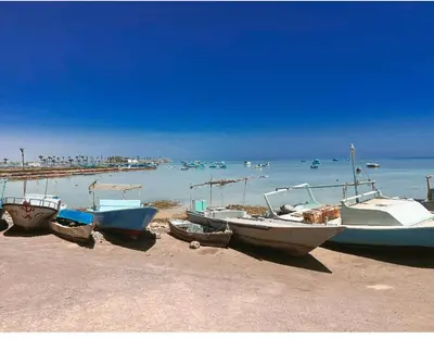 a group of boats sitting on the beach at Sea Life Hurghada Apartments in Hurghada