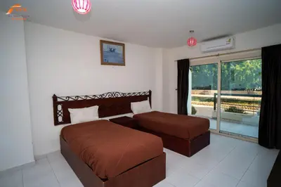 a bedroom with a bed and a couch and a window at Captain Beach Resort Suite in Hurghada