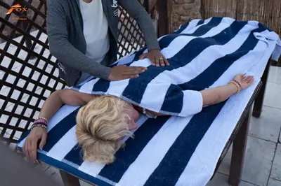 a woman laying on a bed with a blanket at Captain Beach Resort Suite in Hurghada