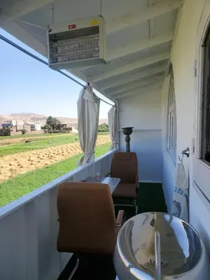 a room with chairs and a table and a view of a field at Casa Helvetica in Luxor