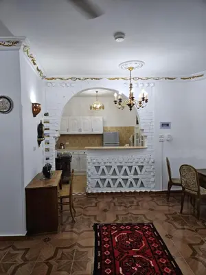 a kitchen with a table and chairs and a chandelier at Casa Helvetica in Luxor