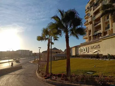 a street with palm trees in front of a building at Egypt Traveler Hotel in Hurghada