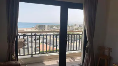 a room with a view of the ocean from a balcony at Egypt Traveler Hotel in Hurghada