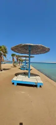a beach with a large umbrella on the beach at Egypt Traveler Hotel in Hurghada