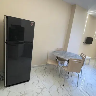 a dining room with a table and a black refrigerator at منتجع جوليانا بيتش ريزورت in Hurghada