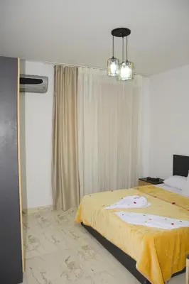 a bedroom with a bed and a chandelier at Luxe Apartment Inside Karma Beach Resort Al Ahiaa-Beach Free Access in Hurghada