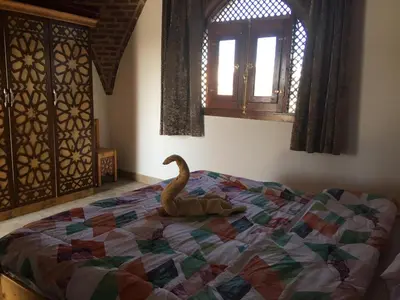 a bedroom with a bed with a swan on it at Garden view guest house in Luxor