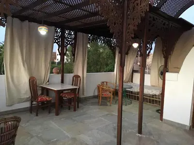 a patio with a table and chairs and a table and a tent at Garden view guest house in Luxor