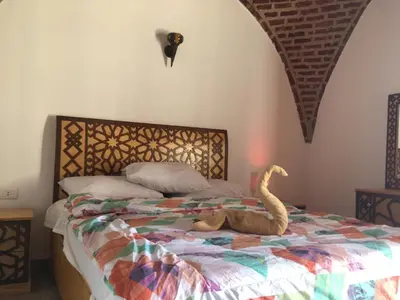 a bedroom with a bed with a stuffed snake on it at Garden view guest house in Luxor