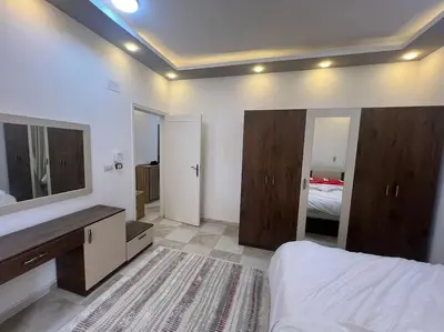 a bedroom with a bed and a sink and a mirror at Spacious 2-Bedroom Apartment - Families Only in Hurghada