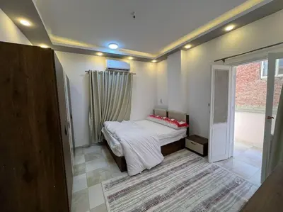 a bedroom with a bed in a room with a window at Spacious 2-Bedroom Apartment - Families Only in Hurghada