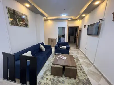 a living room with a blue couch and a table at Spacious 2-Bedroom Apartment - Families Only in Hurghada