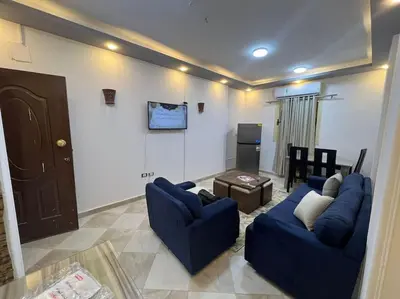 a living room with two blue couches and a tv at Spacious 2-Bedroom Apartment - Families Only in Hurghada