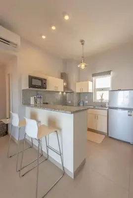 a kitchen with a counter with chairs and a refrigerator at El-Gouna Water-Side Apartment in Hurghada