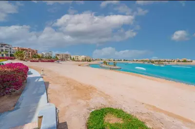 a sandy beach with buildings and the ocean at El-Gouna Water-Side Apartment in Hurghada