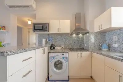 a white kitchen with a washing machine in it at El-Gouna Water-Side Apartment in Hurghada