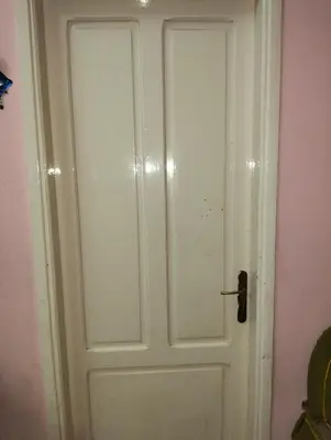 a white door in a room with a pink wall at مدينة القصير in Quseir