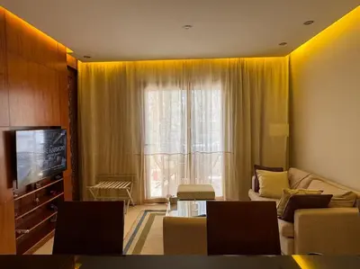 a living room with a couch and a tv at Ancient Sands Golf Resort El Gouna Luxury Apartment in Hurghada