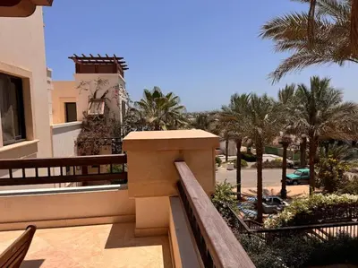 a balcony of a building with palm trees at Ancient Sands Golf Resort El Gouna Luxury Apartment in Hurghada