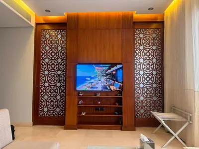 a living room with a tv and a wooden wall at Ancient Sands Golf Resort El Gouna Luxury Apartment in Hurghada