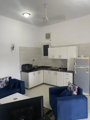 a kitchen with white cabinets and blue chairs at Nile Ruby Luxor in Luxor