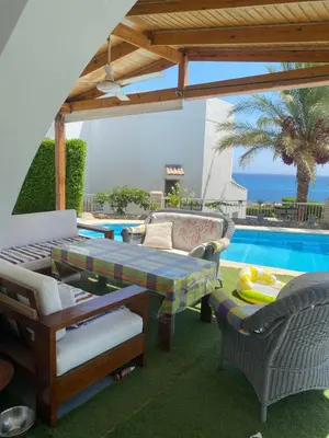 a patio with a table and chairs and a pool at Hurghada Egypt Gable Al Haream Next-door to Hilton Plaza in Hurghada