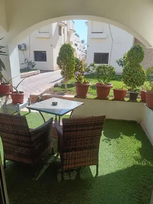 a patio with a table and chairs and potted plants at Elixir in Hurghada