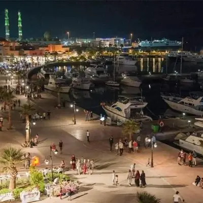 a group of people walking around a marina at night at Comfort Marine in Hurghada