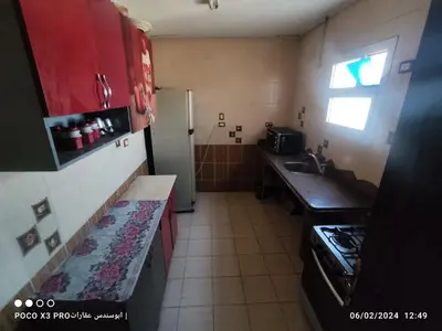 a small kitchen with a sink and a refrigerator at شقة مفروشة رائعة كورنيش النيل برج الرياض in Naj‘ al ‘Amrāb