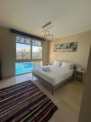 a bedroom with a bed and a large window at Mangroovy retreat in Hurghada