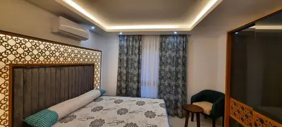 a bedroom with a bed and a chair and a window at Fanadir Bay in Hurghada