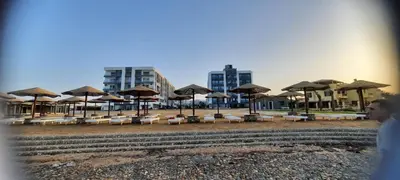 a group of chairs and umbrellas on a beach at Fanadir Bay in Hurghada