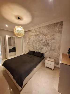 a bedroom with a large black bed and a wall at Hurghada Flat in Hurghada