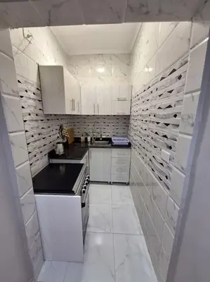 a white kitchen with white cabinets and a stove at Hurghada Flat in Hurghada