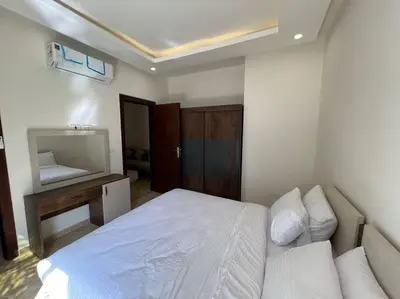 a bedroom with a white bed and a mirror at Elegant 2-Bedroom Suite Mirage Bay in Hurghada