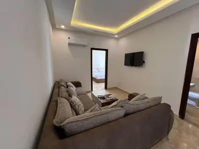 a living room with a large couch and a tv at Elegant 2-Bedroom Suite Mirage Bay in Hurghada
