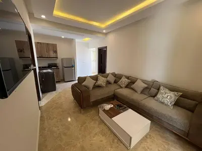 a living room with a couch and a table at Elegant 2-Bedroom Suite Mirage Bay in Hurghada
