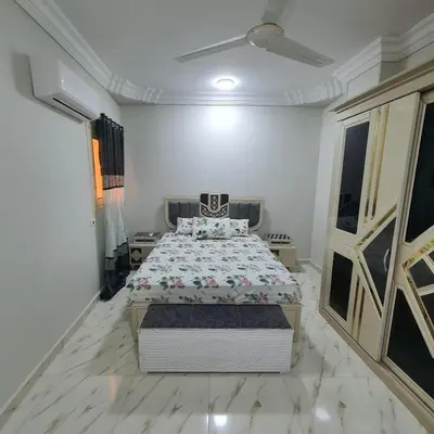 a bedroom with a bed in a white room at Lareen's apartment in Quseir