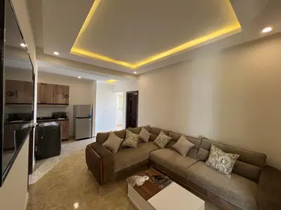 a living room with a couch and a kitchen at Chalet in mirage resort bay resort & aqua park in Hurghada