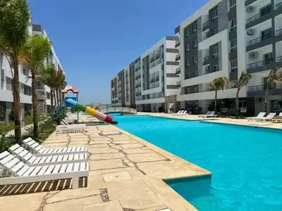 a pool with a slide in front of a building at Fanadir Bay Hurghada in Hurghada