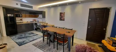 a kitchen with a wooden table and some chairs at Fanadir Bay Hurghada in Hurghada