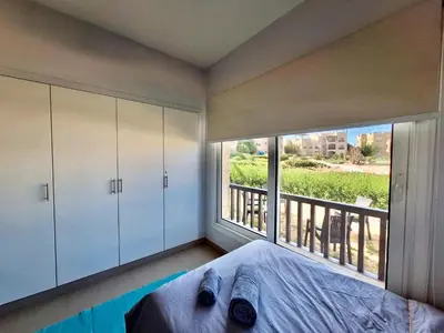 a bedroom with a bed and a large window at El Gouna Waterside E 1-Bedroom Ground Floor Sleeps 4 Persons in El Gouna