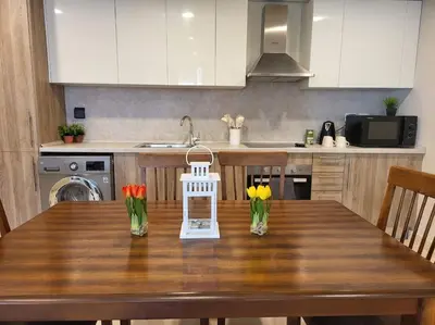 a kitchen with a wooden table with flowers in vases at Mangroovy- 1BR Sparkling Condo in Hurghada