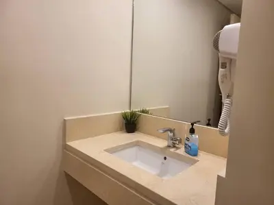 a bathroom with a sink and a mirror at Mangroovy- 1BR Sparkling Condo in Hurghada
