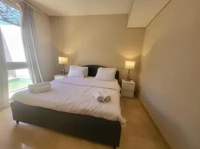 a bedroom with a large bed with towels on it at Mangroovy- 1BR Sparkling Condo in Hurghada