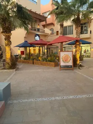 a restaurant with umbrellas and a sign in front of a building at Luxury One Bedroom Apartment with Sea view in SomaBay in Hurghada