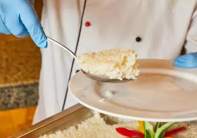 a person holding a spoon with a piece of cake on a plate at Davinci Beach Resort in Hurghada