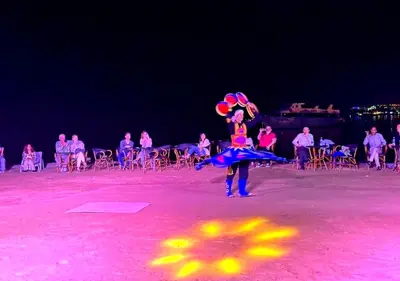 a person standing on a beach holding balloons and an umbrella at Davinci Beach Resort in Hurghada